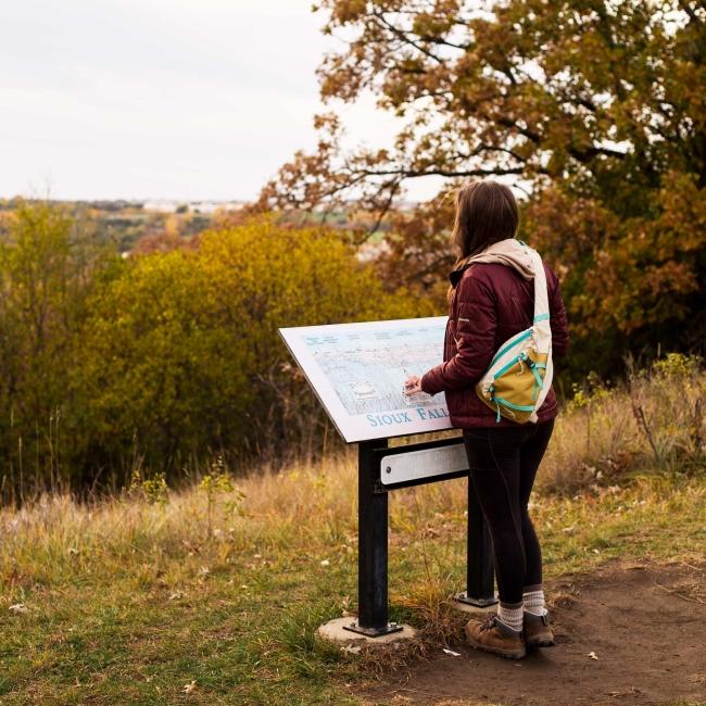 Woman at trail map in fall