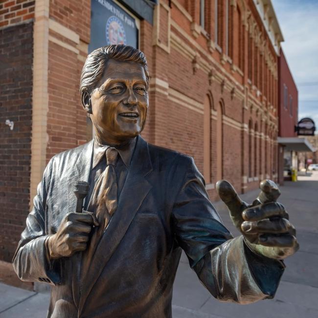 The statue of Bill Clinton holds a microphone in downtown Rapid City