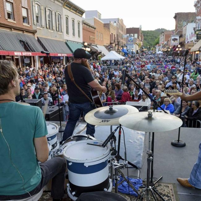 A street in Historic Deadwood is packed with people as a band performs at Wild Bill Days. Deadwood, South Dakota.