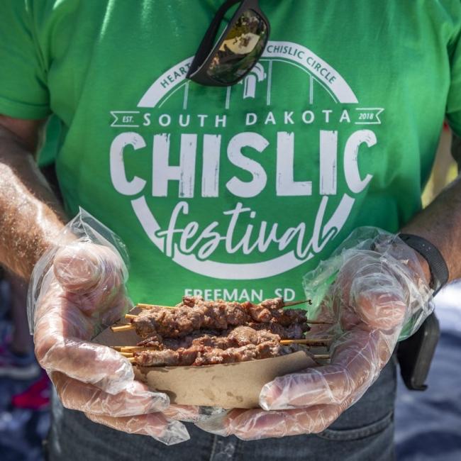 Man holding a plate of chislic at the South Dakota Chislic Festival.