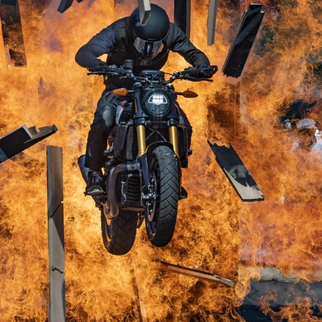 Motocross biker leaping through fire on his bike.