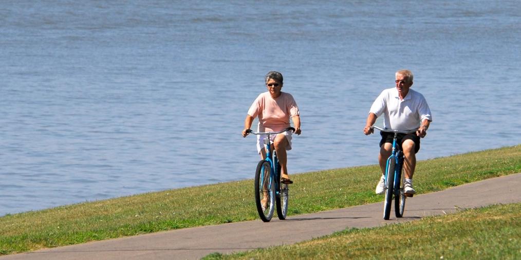 elderly couple biking near river