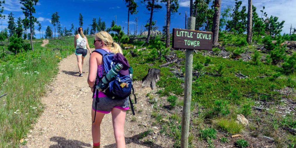 Hikers passing sign for little Devil's Tower
