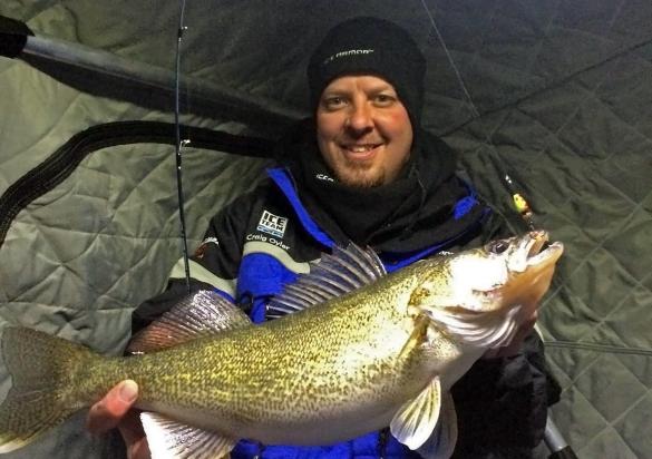 Ice fisherman with fish in shack