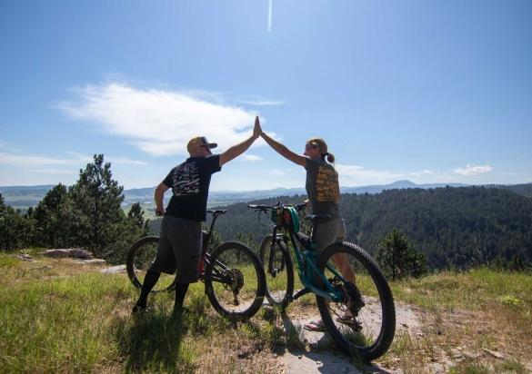 Man and woman mountain bikers hi-fiving