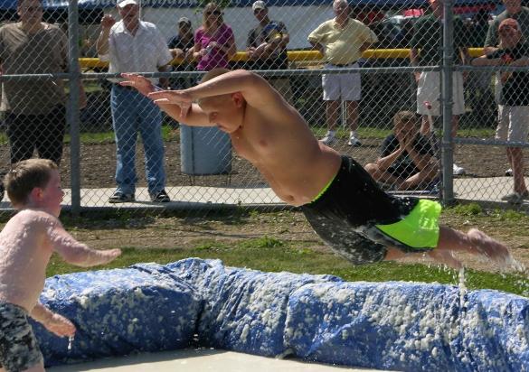 A boy launches against his opponent in a ring of mashed potatoes during Clark's Potato Days celebration