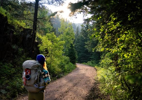 Female backpacker hiking a section of the 109-mile George S. Mickelson Trail on an early fall morning in the Black Hills of South Dakota.