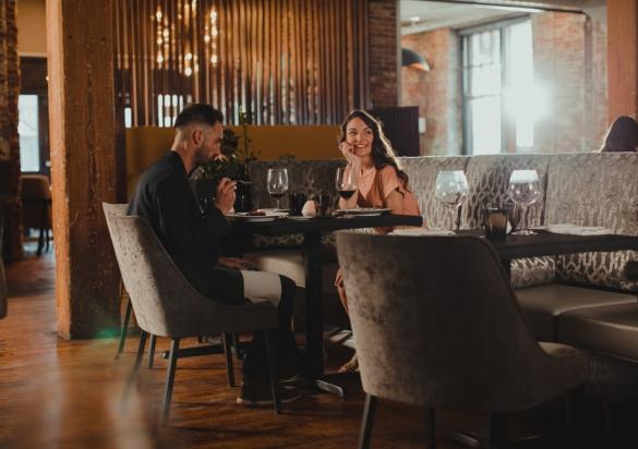 Couple dining with the woman looking happy in the luxurious Harvester Kitchen.