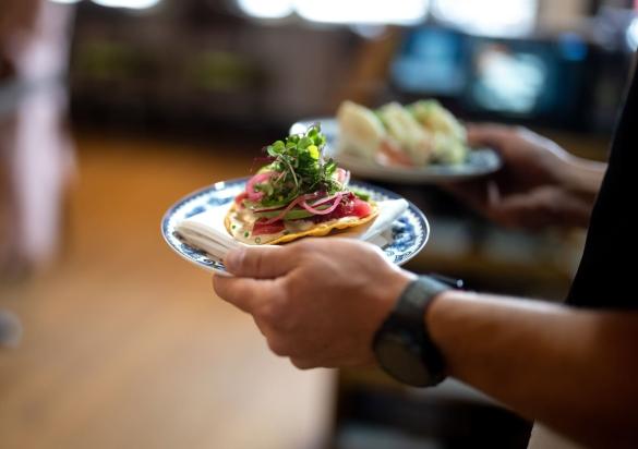 Waiter carrying small plates to table at Skogen Kitchen in Custer, South Dakota.