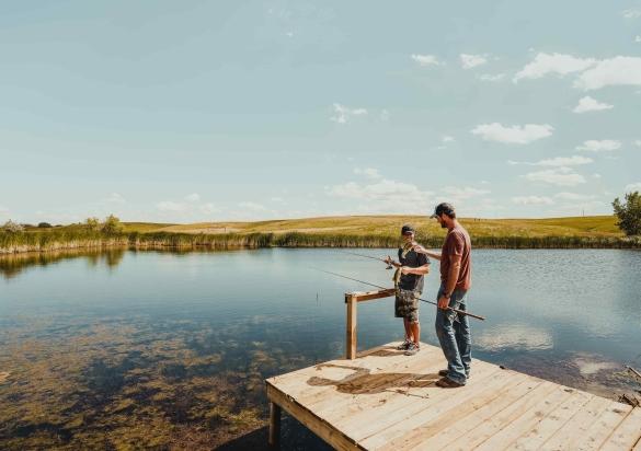 Two people shore-fish off a dock