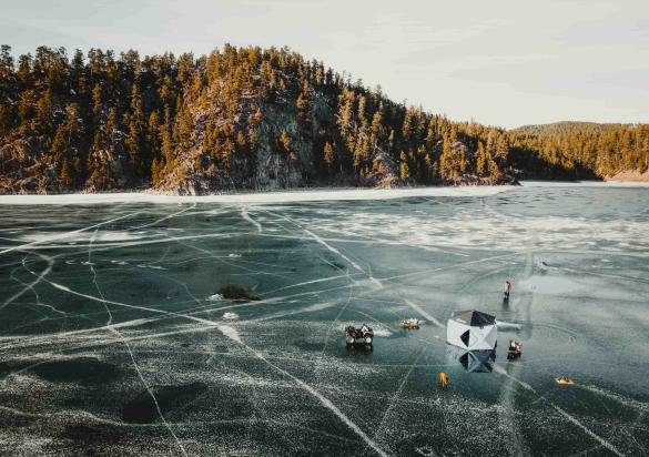 A vast frozen lake with white cracks holds up ice fisherman in the Black Hills