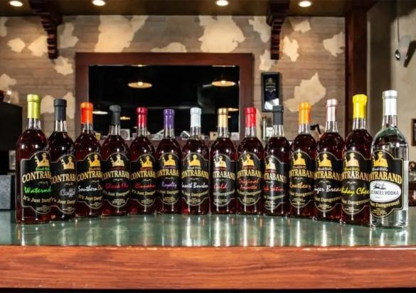 Bottles of liquor from Black Hills Contraband Distillery stand in a row on a bar top. Rapid City, South Dakota.