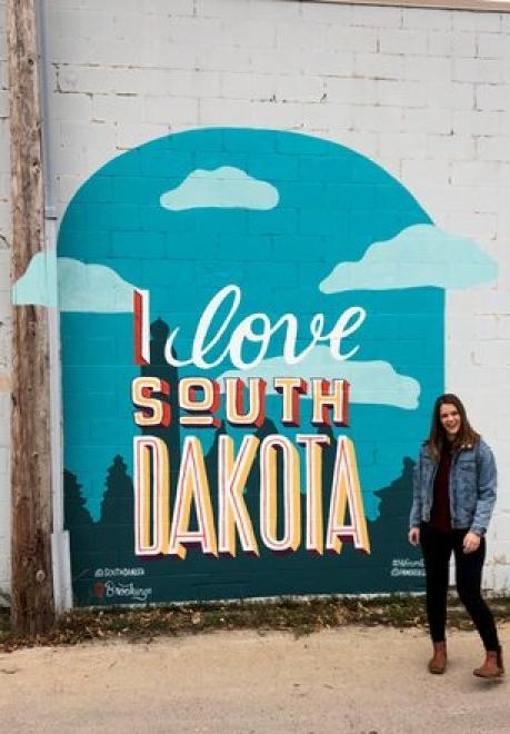 Woman happy in front of I Love SD sign