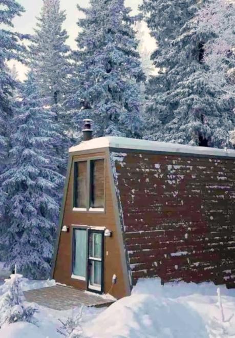 A vintage A-Frame Cabin tucked in the snow-clad Black HIlls during winter