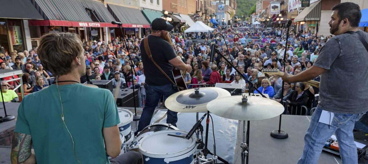 A street in Historic Deadwood is packed with people as a band performs at Wild Bill Days. Deadwood, South Dakota.