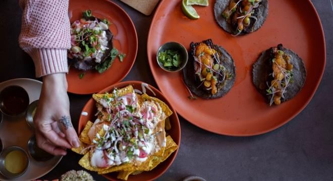 Overhead shot of a plate of nachos on a table with a dark blue tablecloth at BiBiSol restaurant in Sioux Falls, South Dakota.