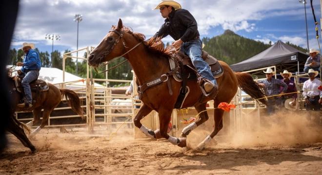 a cowboy rides on horseback at a rodeo in South Dakota.